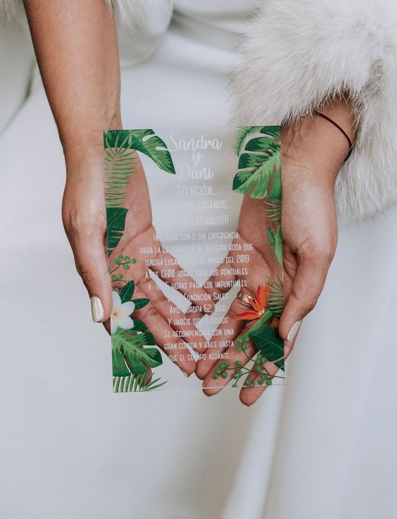 a pretty acrylic tropical invitation with leaves and blooms painted is a fresh idea for a modern wedding