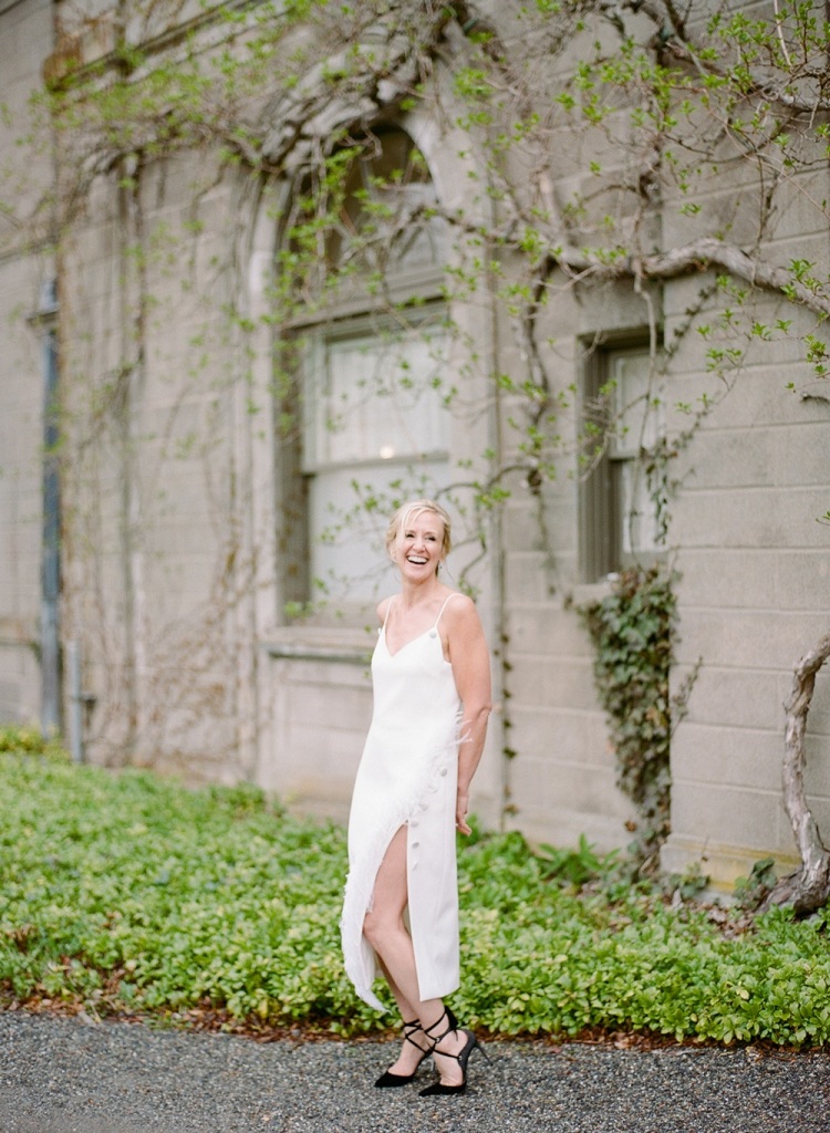 a beautiful and chic reception wedding dress - a midi slip dress decorated with buttons that create a slit, black strappy heels