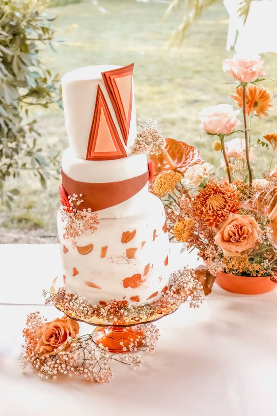 04 a bold wedding cake with a striped tier, brushstrokes and dimensional triangles plus fresh blooms for a boho wedding