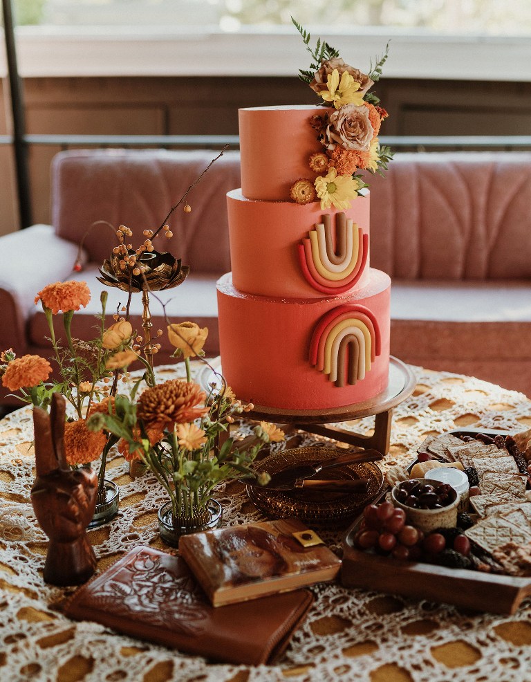 06 a coral wedding cake with bright blooms and bold geometric detailing is a lvoely idea for a colorful 70s wedding with a boho feel