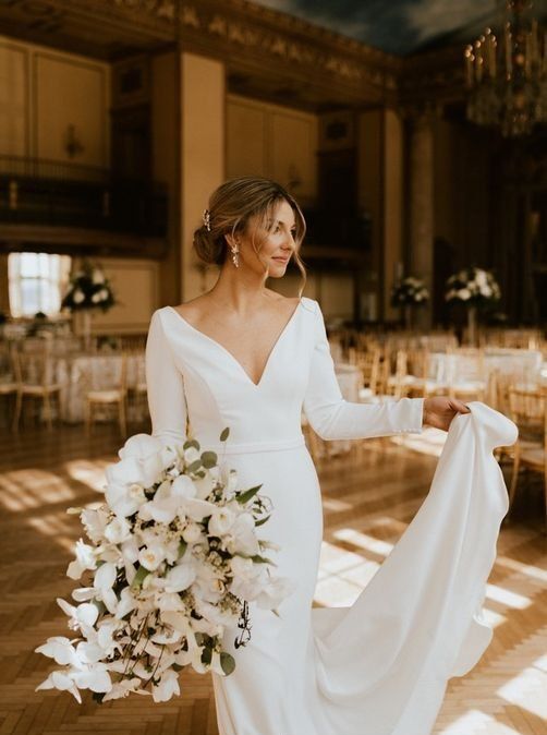 10 a modern glam wedding dress – a plain sheath one with a deep V neckline and long sleeves plus a train