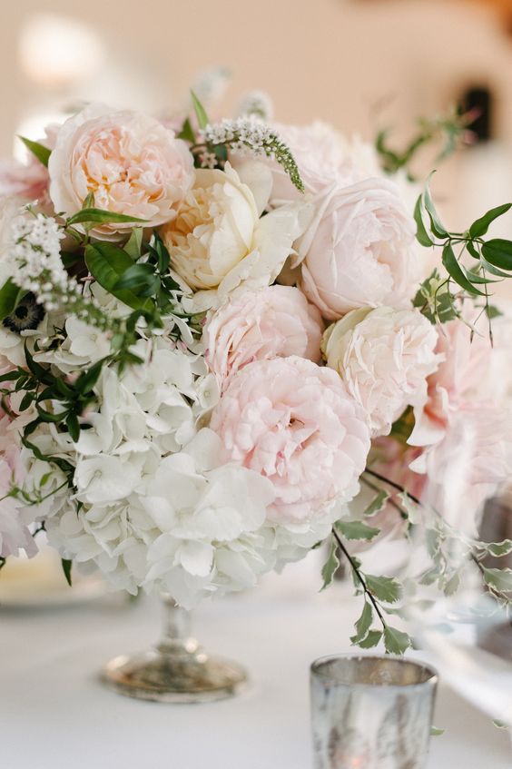a tender wedding centerpiece with blush peonies, white hydrangeas, greenery and branches is a lovely idea for a spring or summer wedding