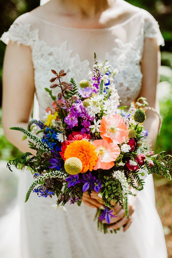 a bold wedding bouquet with yellow, pink, purple, blue flowers, greenery, astilbe and billy balls is cool and bright