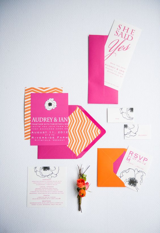 a colorful modern wedding invitation suite with hot pink envelopes and invites, with orange prints and cool letters