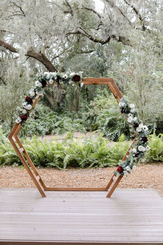 a lovely wedding arch decorated with pale foliage, white and deep purple blooms is a fantastic idea for a fall or winter wedding