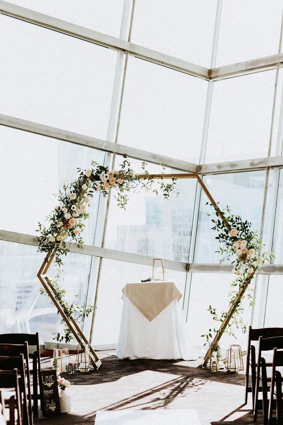 an airy hexagon wedding arch with greenery and blush flowers is a chic and stylish idea for a spring wedding