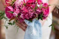 04 a super bold hot pink wedding bouquet of peonies and ranunculus, some greenery and wide blue striped ribbons