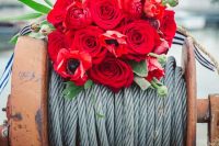 06 a nautical wedding bouquet of red roses and ranunculus, some greenery and striped ribbons is chic