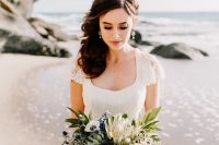16 a chic modern nautical wedding bouquet with king proteas, white anemons, blue blooms and thistles, greenery is a beautiful idea for a seaside wedding