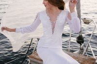 17 a modern plain fitting wedding dress with lace and embellishments, long sleeves, a covered neckline and a train