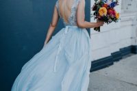 23 a romantic light blue wedding dress with an embellished bodice with an open back and a layered maxi skirt is chic