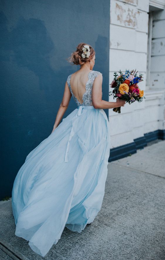 a romantic light blue wedding dress with an embellished bodice with an open back and a layered maxi skirt is chic