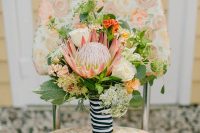 26 a nautical wedding bouquet of white and orange roses, a king protea, greenery and a striped ribbon for a bouquet wrap