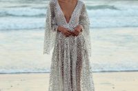 27 a sparkling silver A-line dress with a plunging neckline and bell sleeves that is inspired by fish scales