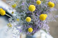 a beautiful billy balls and lavender wedding centerpiece in a silver vase is a stylish idea for a vintage wedding