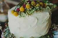a beautiful summer wedding cake topped with billy balls, waxflowers and some bright allium is ideal for a wildflower wedding