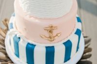 a chic nautical wedding cake with a white rope, blush, navy stripe tier plus a gold anchor is a gorgeous idea to rock