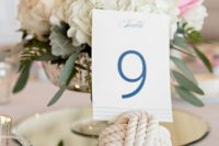a chic wedding centerpiece with white and pink blooms in a refined bowl, a rope knot with a table number is classics