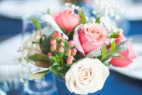a lovely and easy nautical wedding centerpiece of a navy vase, white and pink roses and baby’s breath plus berries is amazing