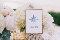 a lovely nautical wedding centerpiece of white and blush blooms, a rope ball with a table number