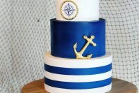 a nautical wedding cake with a striped, a bold blue and a compass tier, a rope tier and an anchor is a stylish and bold idea to rock