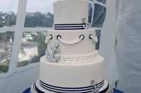 a nautical wedding cake with navy and white stripes, rope, anchor decor is an amazing and very cheerful nautical idea to try
