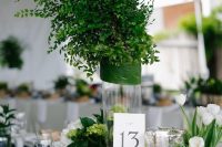 a nautical wedding table setting with white linens, a navy table runner, a rope knot, a greenery arrangement and white tulips is chic