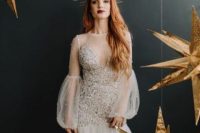 a sheath wedding dress with an embellished bodice, illusion puff sleeves and a tiered skirt, an illusion high neckline for a bold celestial look
