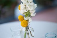 a simple spring or summer wedding centerpiece of billy balls and a white blooming branch is a pretty idea to rock