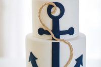 a stylish nautical wedding cake in white, with a large navy anchor, gold rope is an amazing idea to rock for your seaside wedding