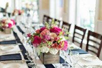 a stylish nautical wedding tablescape with a striped runner and navy napkins, bold pink florals and greenery is a chic and cool idea