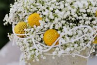 a stylish wedding centerpiece of concrete, with billy balls and baby’s breath is a cool idea for spring or summer