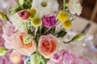 a summer wedding centerpiece of pink and peachy blooms, white flowers, greenery and billy balls is a bright and cool idea