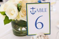 a very simple nautical wedding centerpiece of white roses, a rope ball with a table number is a perfect idea to rock