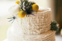 a white ruffle wedding cake with a succulent,a  white peony, thistles, billy balls is a stylish idea for a spring or summer wedding