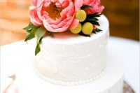 a white textural wedding cake with coral peonies and billy balls is a pretty and stylish idea with plenty of color