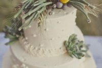 a white textural wedding cake with succulents, greenery on top and billy balls is amazing for spring or summer