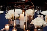 an elegant nautical wedding centerpiece of white roses and candles, a candle lantern is an amazing idea for a nautical wedding