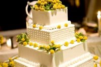 an oversized square wedding cake with lots of billy balls and some foliage is a stylish and refined idea of a wedding dessert