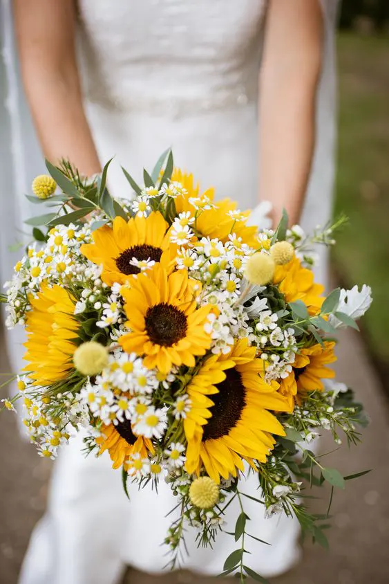 a bright rustic wedding bouquet with sunflowers, billy balls, daisies, greenery is a very summer-like and fun idea to try