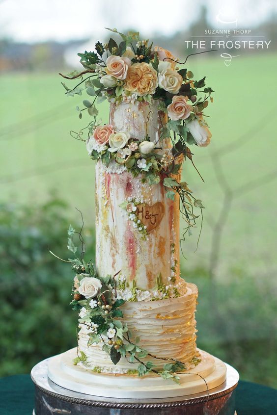 a sophisticated secret garden wedding cake with textural buttercream with gold and pink touches, fresh blooms and greenery si amazing