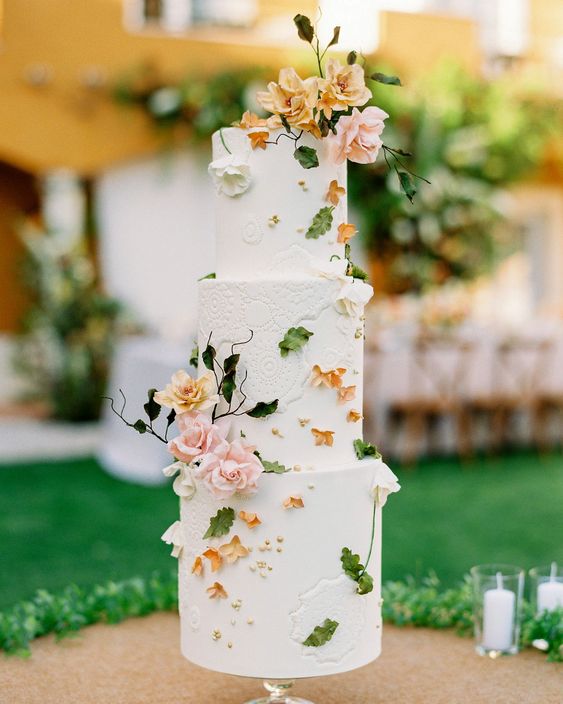 a refined secret garden wedding cake in white and with lots of pink and rust sugar blooms and petals plus sugar foliage
