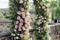 a beautiful and very lush garden wedding arch covered with greenery and pink and white blooms is a chic and bold idea