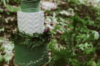 a beautiful enchanted forest wedding cake with a green and a white petal tier, with a white and green ruffles, with greenery decor
