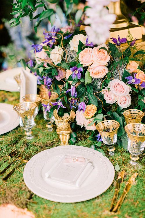 a beautiful secret garden wedding centerpiece of pink roses and purple blooms plus lots of foliage is amazing for summer