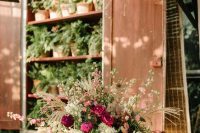 a bold secret garden wedding of a gilded vase, dark blooms and blush ones and some greenery is a chic idea for the fall