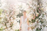 a breathtaking wedding altar with greenery, blush, peachy and white blooms is a very refined and bold idea that will take everyone’s breath away