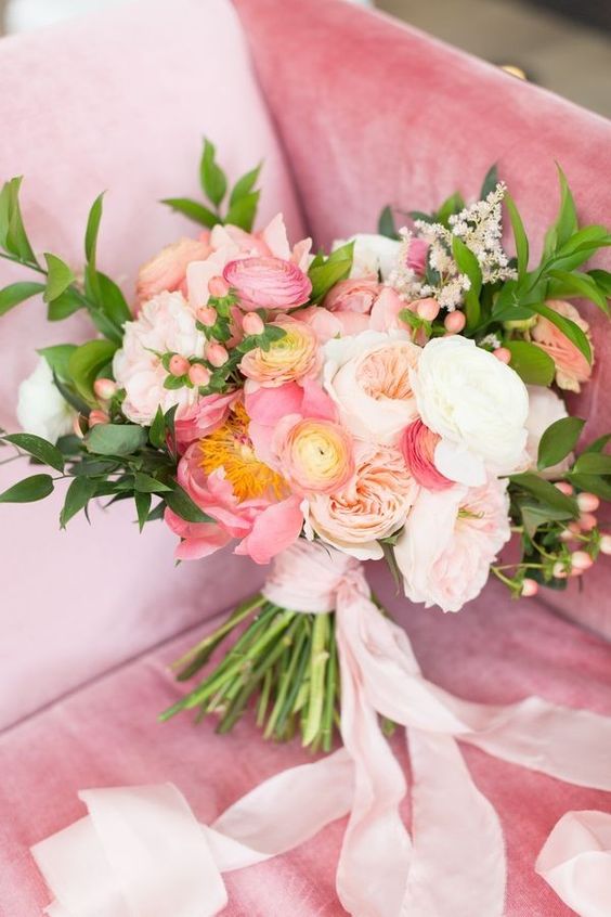 a bright and cool wedding bouquet with pink peonies and pink and white ranunculus, greenery and fillers for spring or summer