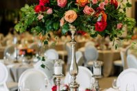a bright floral wedding centerpiece with much greenery and bold blooms looks magical and fantastic, like in a fairy-tale
