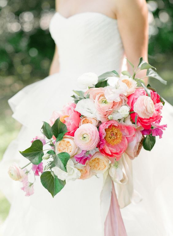 a bright summer wedding bouquet of blush and white ranunculus, pink peonies and some leaves is amazing